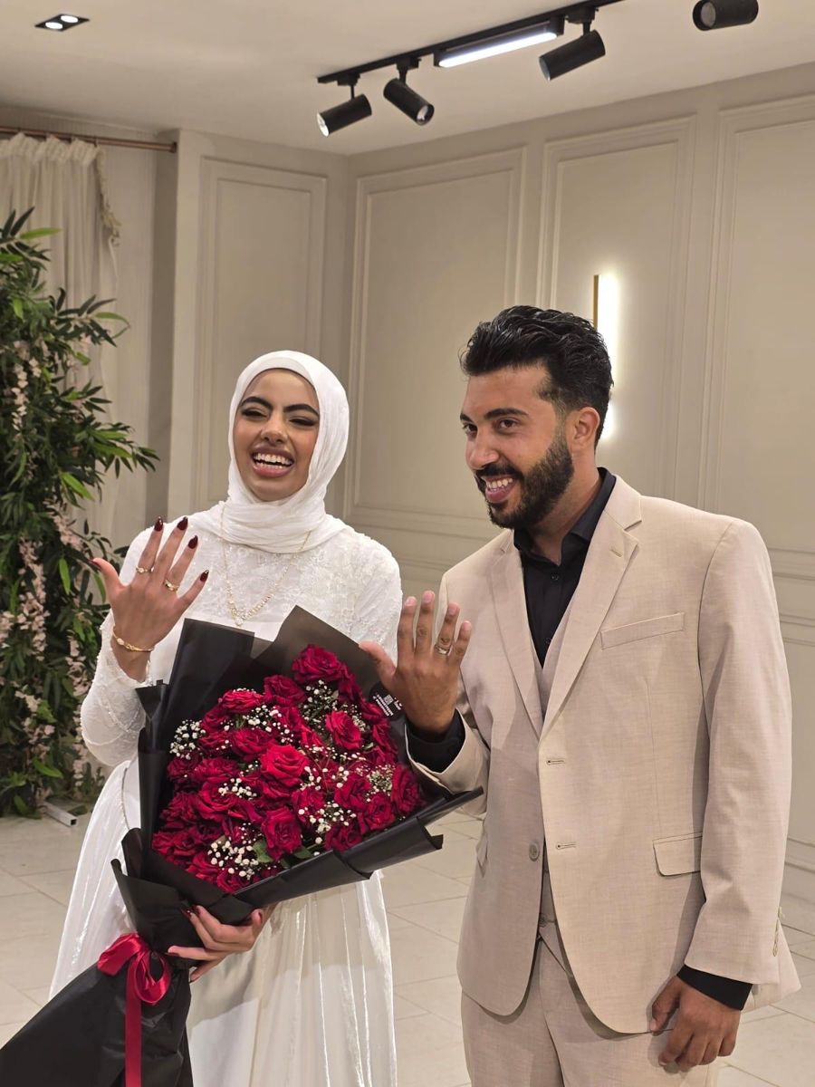 Nada and me holding up our rings, her holding red roses